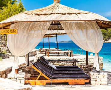 Private beach with deck chairs and canopy.